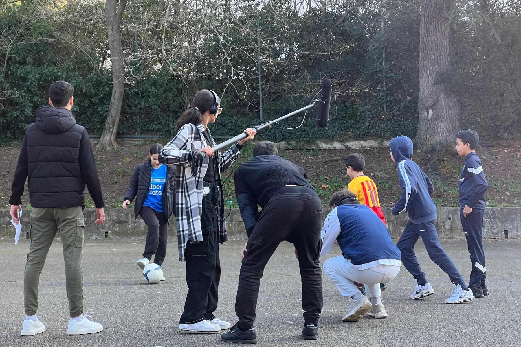 Tournage d'atelier dans une cour, perche son en main